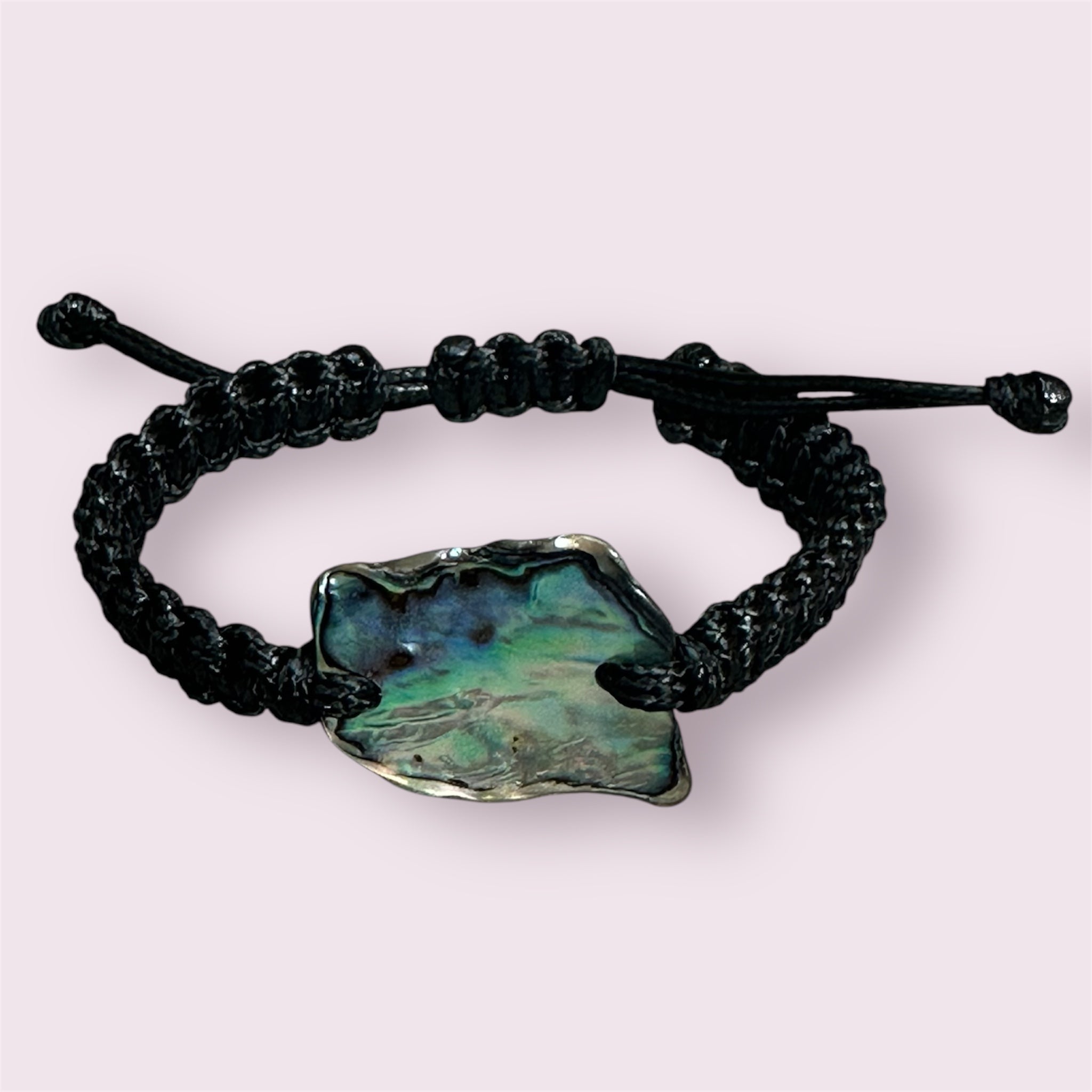Handmade bracelet with square knots and a unique Paua shell with blue and green hues.
