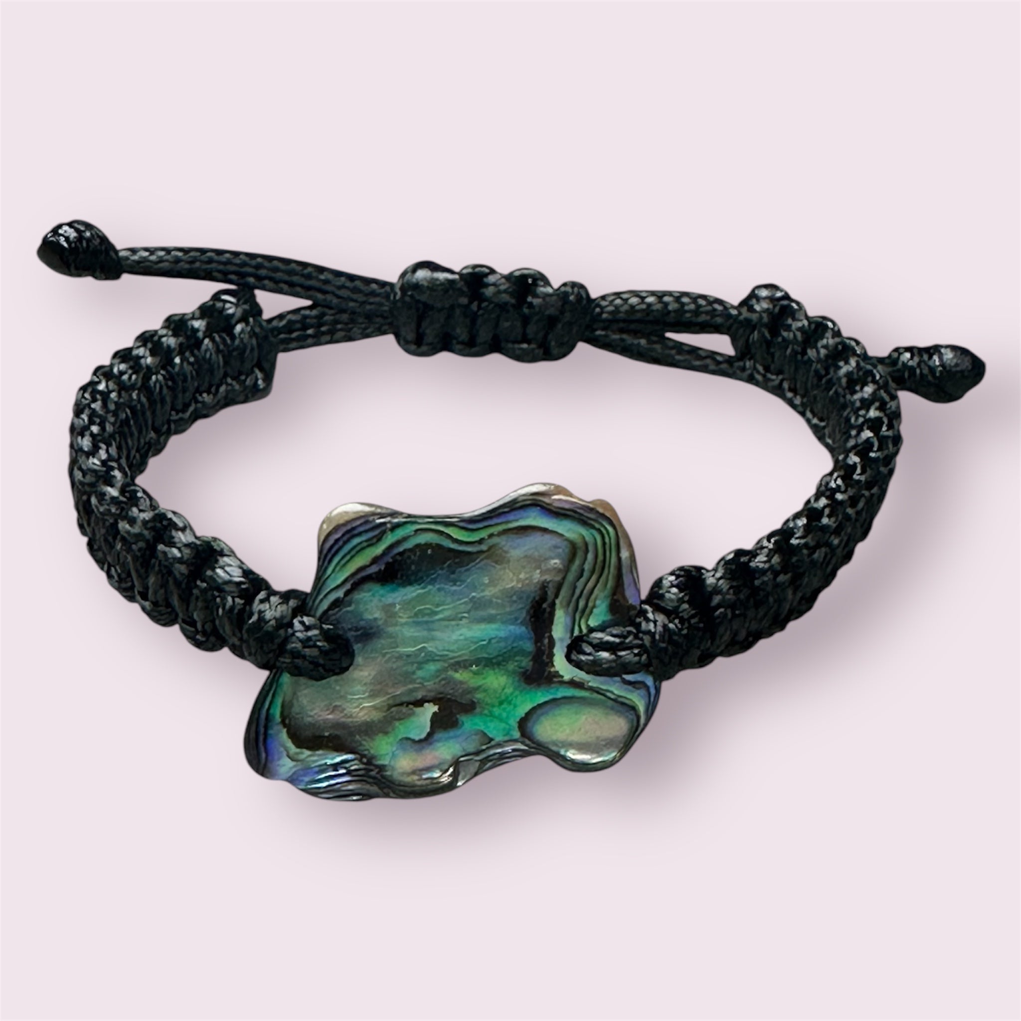 Minimalist black cord bracelet with natural Paua shell, showing shell's colourful texture.