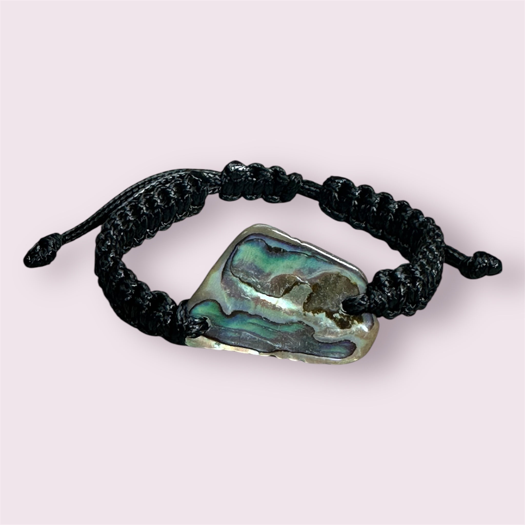 Adjustable handmade bracelet featuring a bold Paua shell centrepiece on strong black cord.